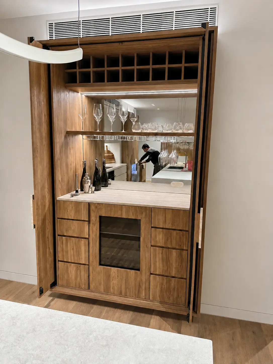 Open custom bar cabinet with integrated lighting, storage and wine refrigerator